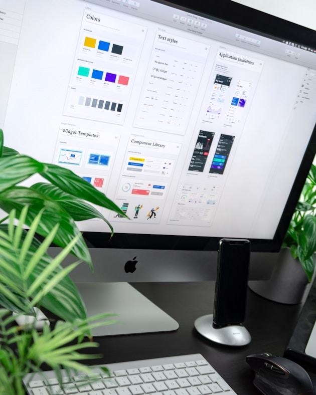 Desktop workspace showing a design system on a large monitor